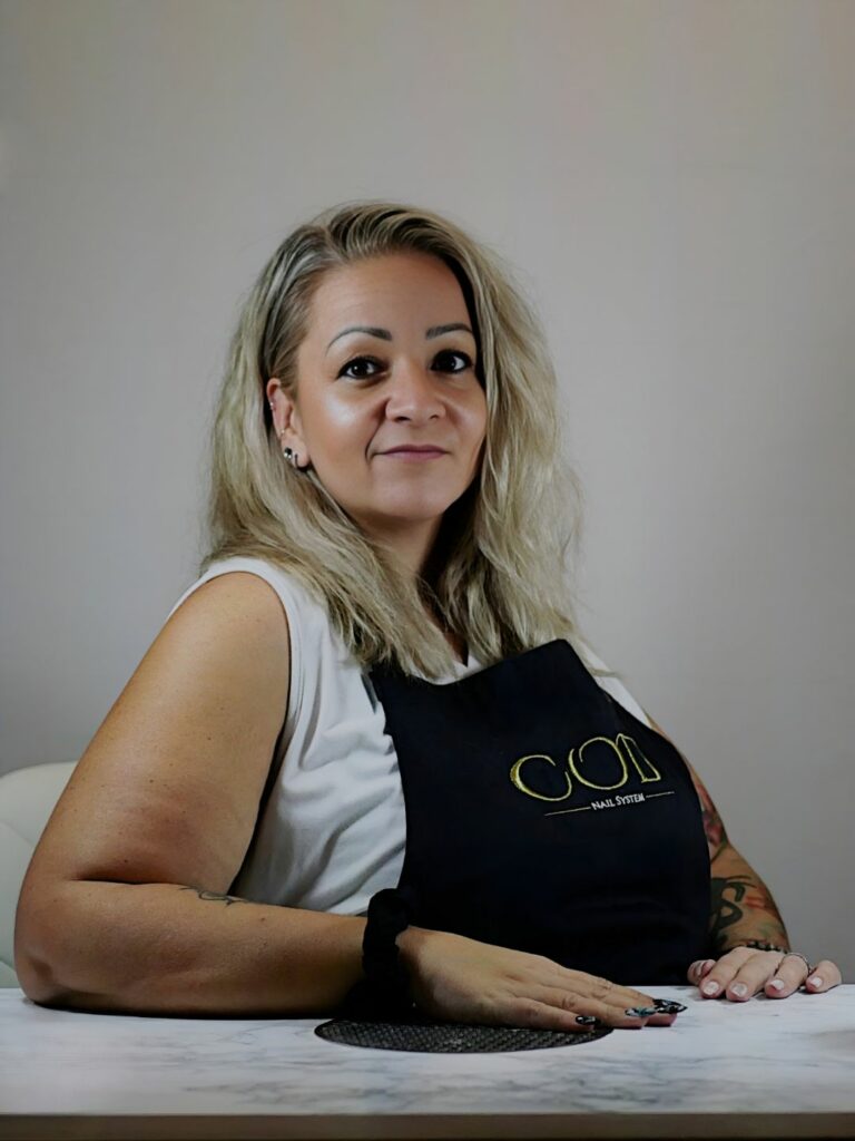 Portrait d’Amélie, formatrice officielle COD Nail System, portant un tablier professionnel COD.