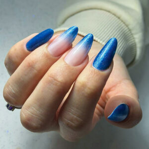Pose gel forme amande avec dégradé bleu pailleté et effet babyboomer inversé sur ongles longs.